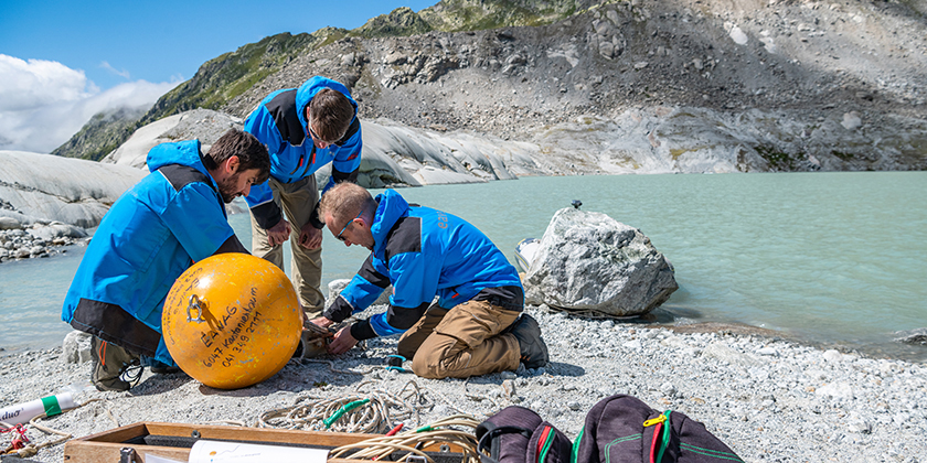 Eawag staff members Brian Sinnet, Michael Plüss and Pascal Rünzi preparing a thermistor measurement chain that measures temperature, pressure and turbidity in glacial lakes. (Photo: Tobias Ryser)