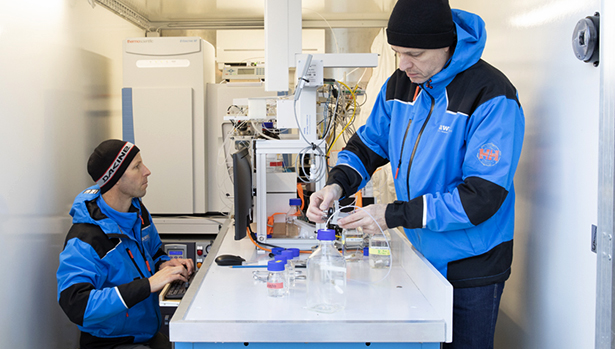 Christoph Ort (links) und Heinz Singer im MS2field-Anhänger, einem automatisierten und mobilen Massenspektrometer, das die Wasserqualität kontinuierlich misst (Foto: Eawag, Aldo Todaro).