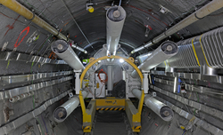 The FE tunnel. Visible in the foreground is a waste canister which, thanks to an integrated heating element, mimics the thermal behaviour of a future canister containing spent fuel. The cigarette-shaped tubes, used to convey the bentonite buffer ...