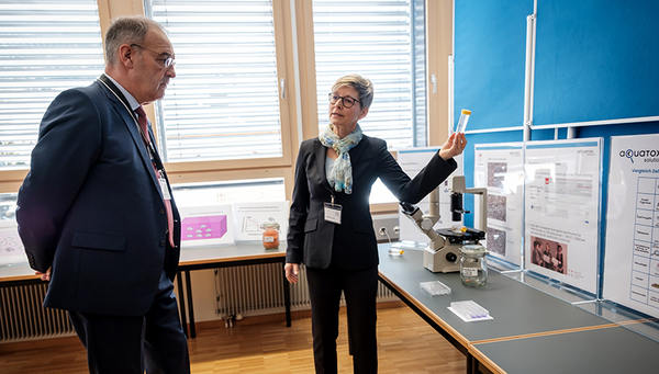 Kristin Schirmer explique au conseiller fédéral Guy Parmelin comment les cellules de branchies des truites arc-en-ciel sont utilisées dans les essais avec les lignées cellulaires de poisson, permettant ainsi de remplacer les essais sur les poissons. Photo: Mallaun Photography