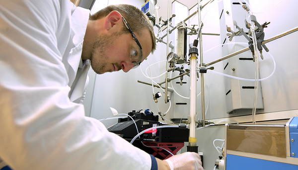 Abb. 1: Der Wissenschaftler Tony Merle testet das neue Membranverfahren zur Ozonung bromidhaltiger Wässer im Labor. Der Glasreaktor ist mit Ozongas gefüllt, das über eine Teflonmembran ins zu behandelnde Wasser diffundiert. (Foto: Andres Jordi, Eawag)