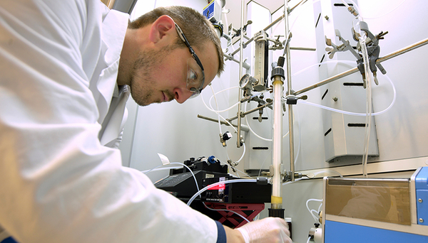 Fig. 1: In the laboratory, scientist Tony Merle tests the novel membrane-based process for ozonation of bromide-containing water: ozone gas fed into a glass reactor diffuses into the water through PTFE membranes. Photo: Andres Jordi, Eawag