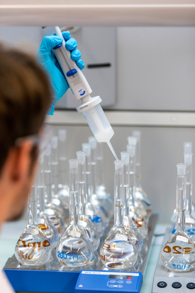 Michael Patrick, assistant scientifique au département de Chimie de l'environnement de l'Eawag, procédant à une extraction liquide-liquide pour extraire et concentrer les pyréthrinoïdes contenus dans les échantillons d'eau. Photo : Alessandro della Bella, Eawag