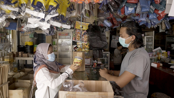 Mauliddiana Nurul Ilyas, collaboratrice du projet SIBRE, fait la promotion des produits à base de larves auprès du détaillant Mas Sueb. Photo: Yosa Padu