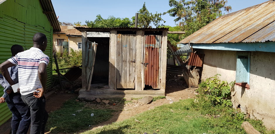 QUISS staff inspect shared sanitation facility in Kisumu, Kenya