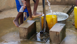 Kinder holen Wasser an einer Fusspumpe im ländlichen Togo (Foto: Jess MacArthur, 2013)