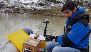 Michael Plüss, technician at Eawag's department Surface Waters, installs a thermistor chain on Lake Stei (Canton Bern, at the Susten Pass). Through automatic series of measurements of water temperature at various depths over several years, the researchers are gaining a better understanding of the general development of high-alpine lakes and their seasonal fluctuations. (Photo: Nico Mölg, Eawag)