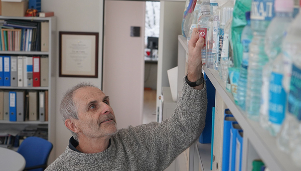 Prof. Urs von Gunten mit einer Sammlung von Trinkwässern aus aller Welt in seinem Büro an der Eawag. (Foto: Andri Bryner)