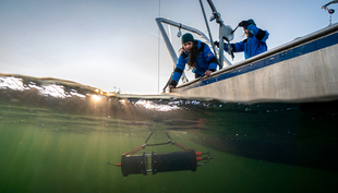 Ecologists Ewa Merz and Thea Kozakiewicz during field work on Lake Greifen (Zurich). Underwater, you can see the Aquascope, an underwater camera that records the tiny creatures in Lake Greifen. (Photo: Eawag, Jonas Steiner)